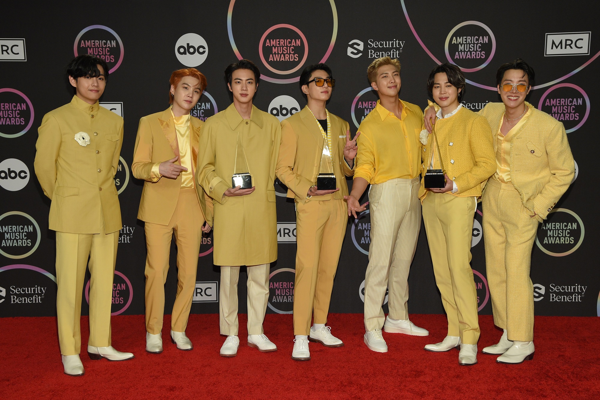 The members of BTS wear yellow outfits on the red carpet at the 2021 American Music Awards