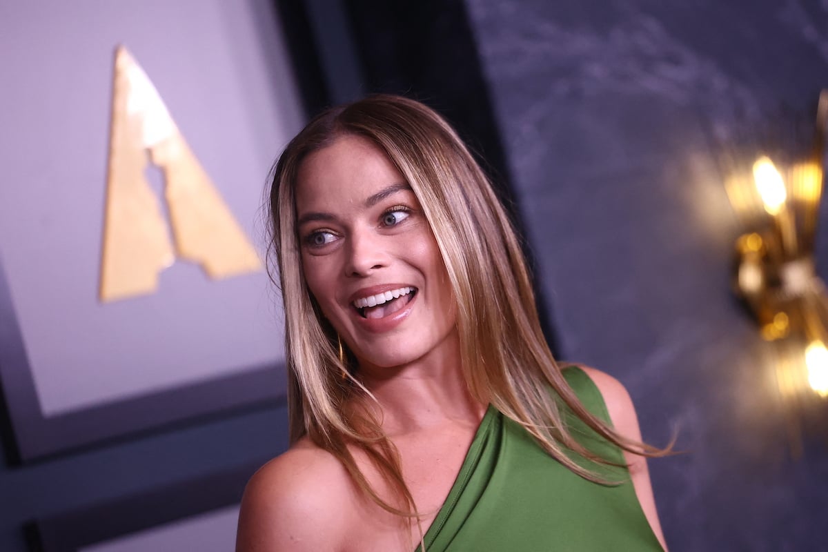 Babylon star Margot Robbie wears a green asymmetrical dress