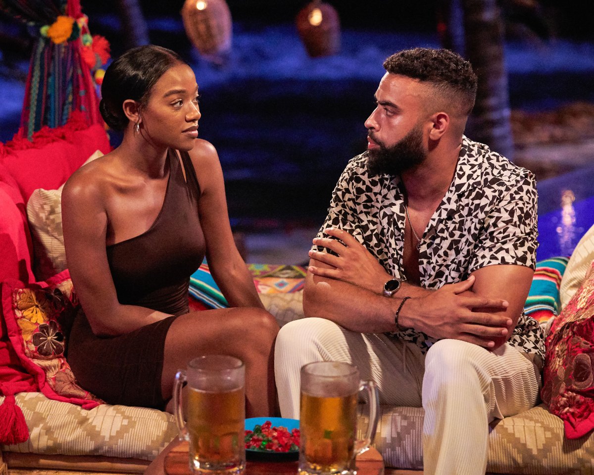 Eliza Isichei and Justin Glaze on Bachelor in Paradise sit and talk on day beds with mugs of beer in front of them.