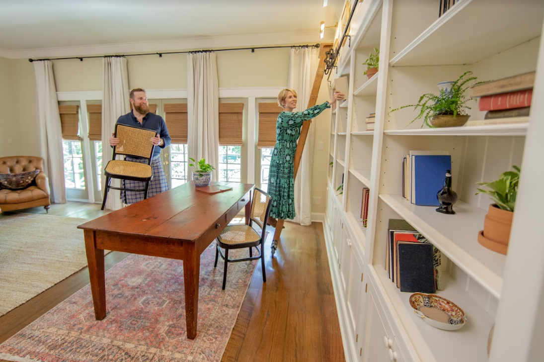 Ben Napier holding a chair while Erin Napier puts things on a shelf in HGTV's 'Home Town'