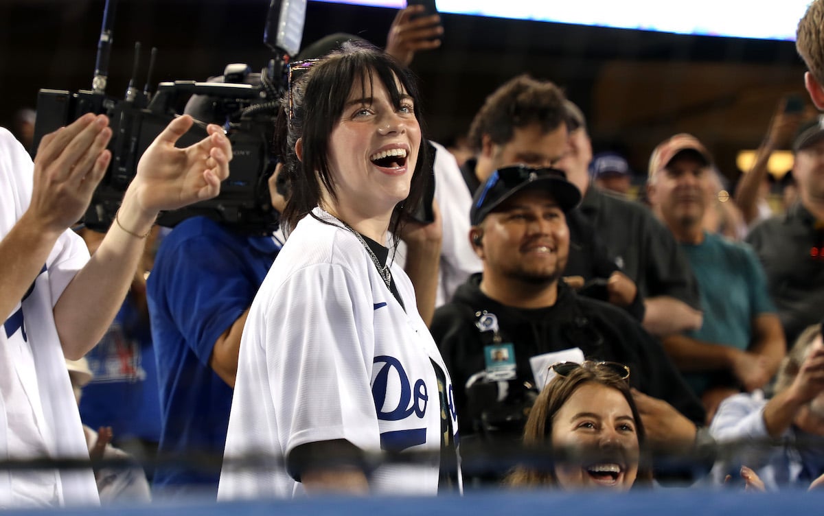Singer Billie Eilish laughs in the front row of an Los Angeles Dodgers game