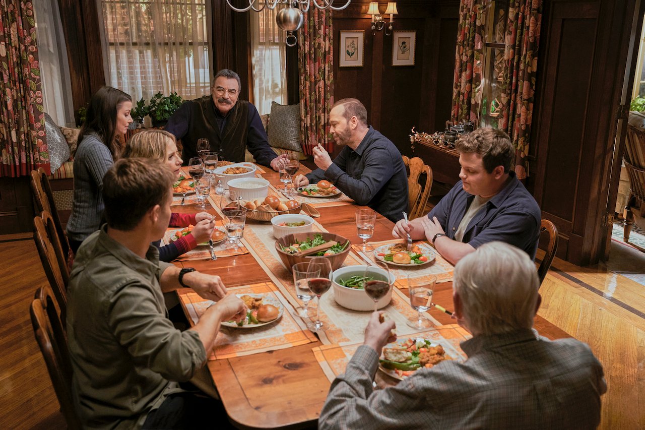 Will Estes as Jamie Reagan, Vanessa Ray as Officer Eddie Janko, Bridget Moynahan as Erin Reagan, Tom Selleck as Frank Reagan, Donnie Wahlberg as Danny Reagan, Andrew Terraciano as Sean Reagan, and Len Cariou as Henry Reagan sit and eat together on 'Blue Bloods'.