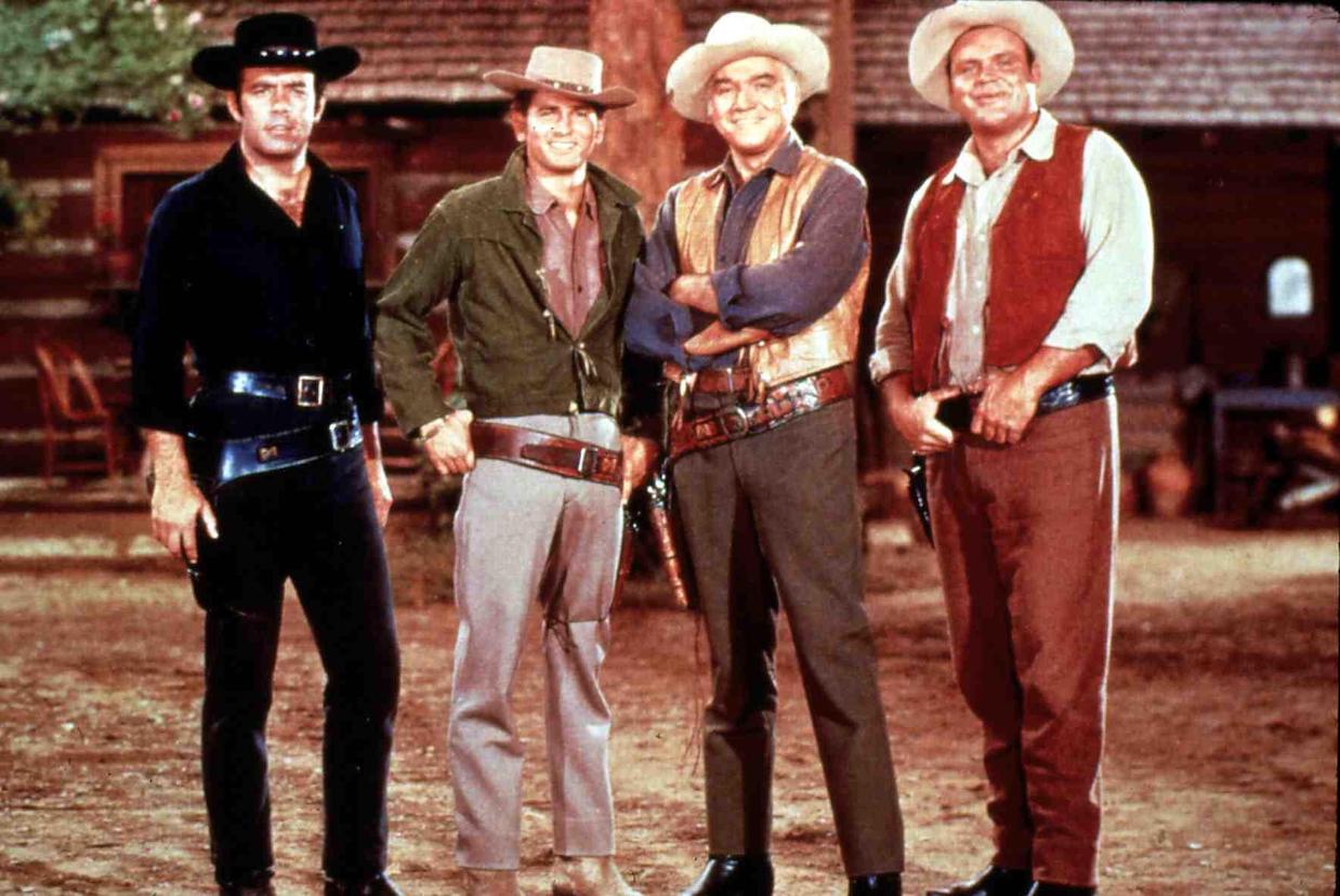 Pernell Roberts, Michael Landon, Lorne Green, and Dan Blocker from the 'Bonanza' cast standing side by side in their Western costumes