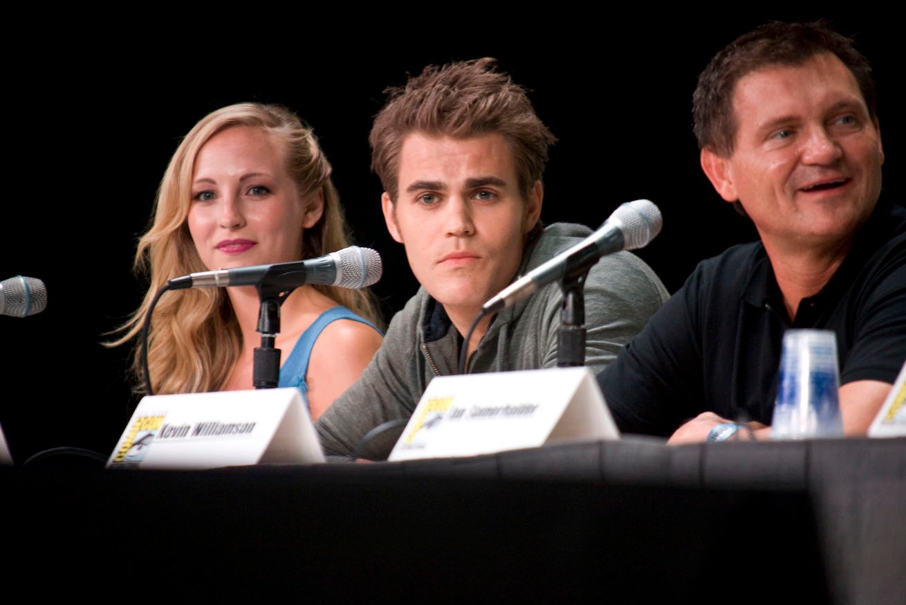 Candice King and Paul Wesley from 'The Vampire Diaries' sitting next to each other at a panel with another man next to them