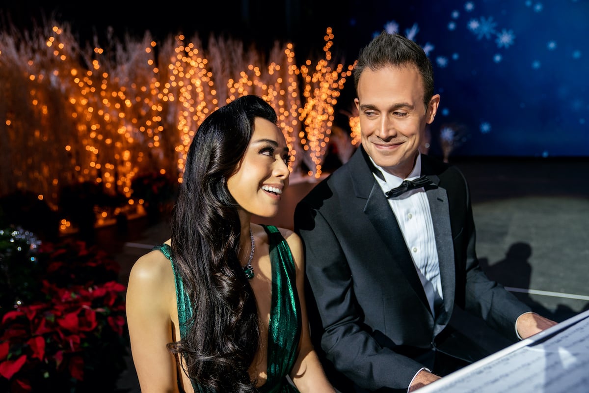 Aimee Garcia sitting next to Freddie Prinze Jr in the movie 'Christmas With You' on Netflix