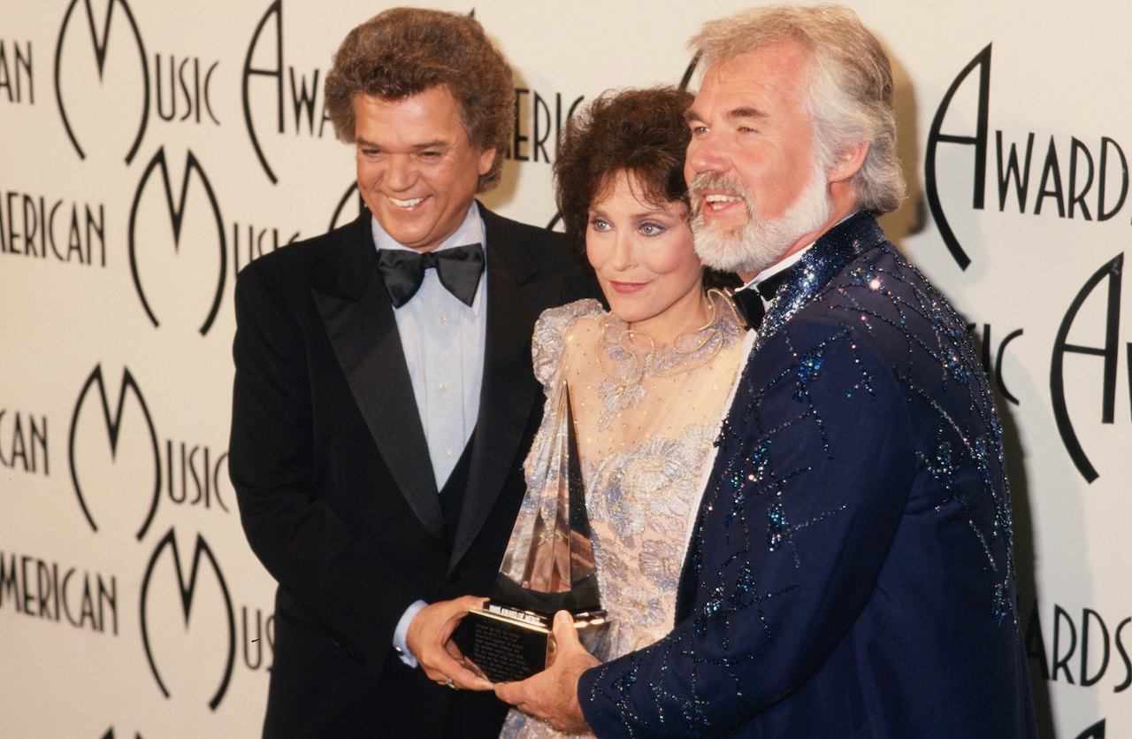 Loretta Lynn poses for a portrait with Conway Twitty (L) and Kenny Rogers (R) at the American Music Awards at the Santa Monica Civic Auditorium on January 16, 1978, in Santa Monica, California.