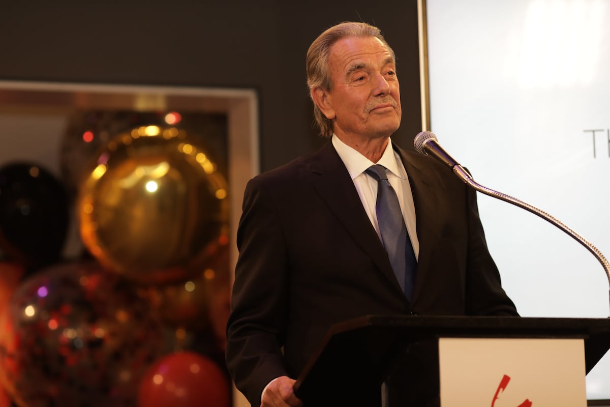 Eric Braeden smiling, behind a podium