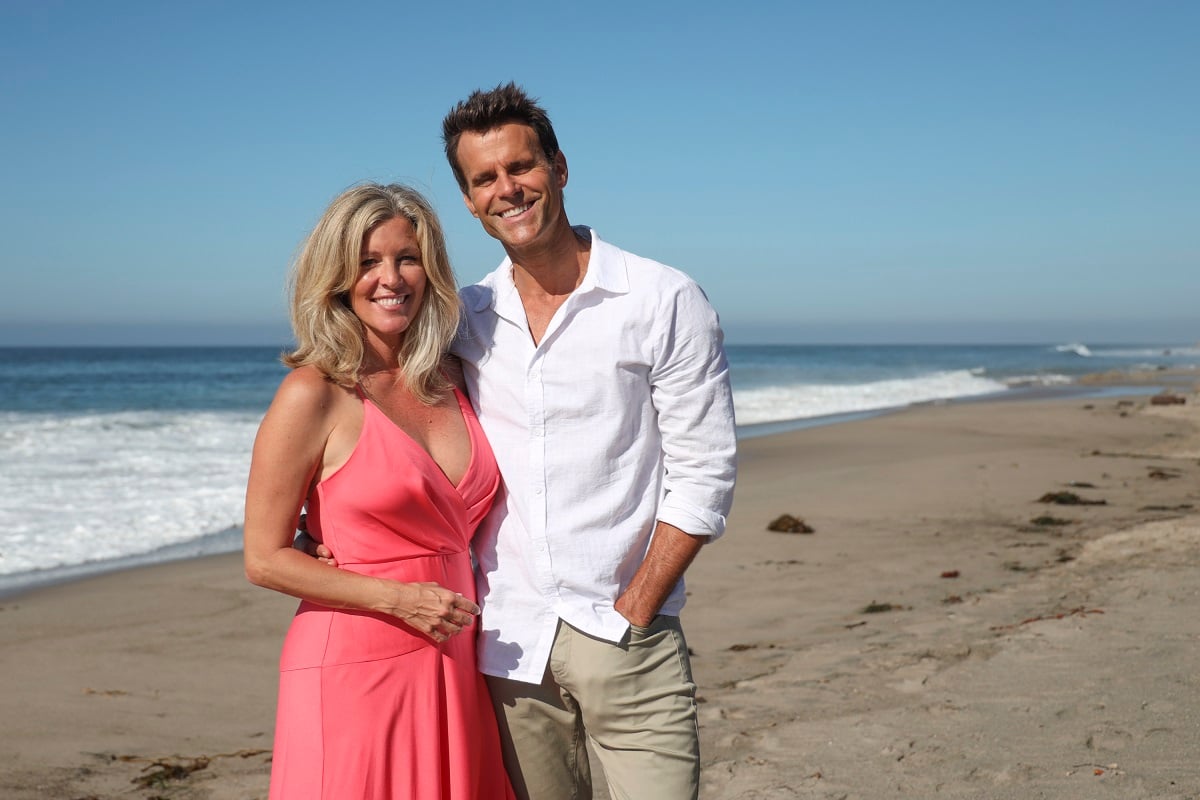 'General Hosptial' star Laura Wright in a pink dress, and Cameron Mathison in khakis and a white shirt, pose together on a beach.