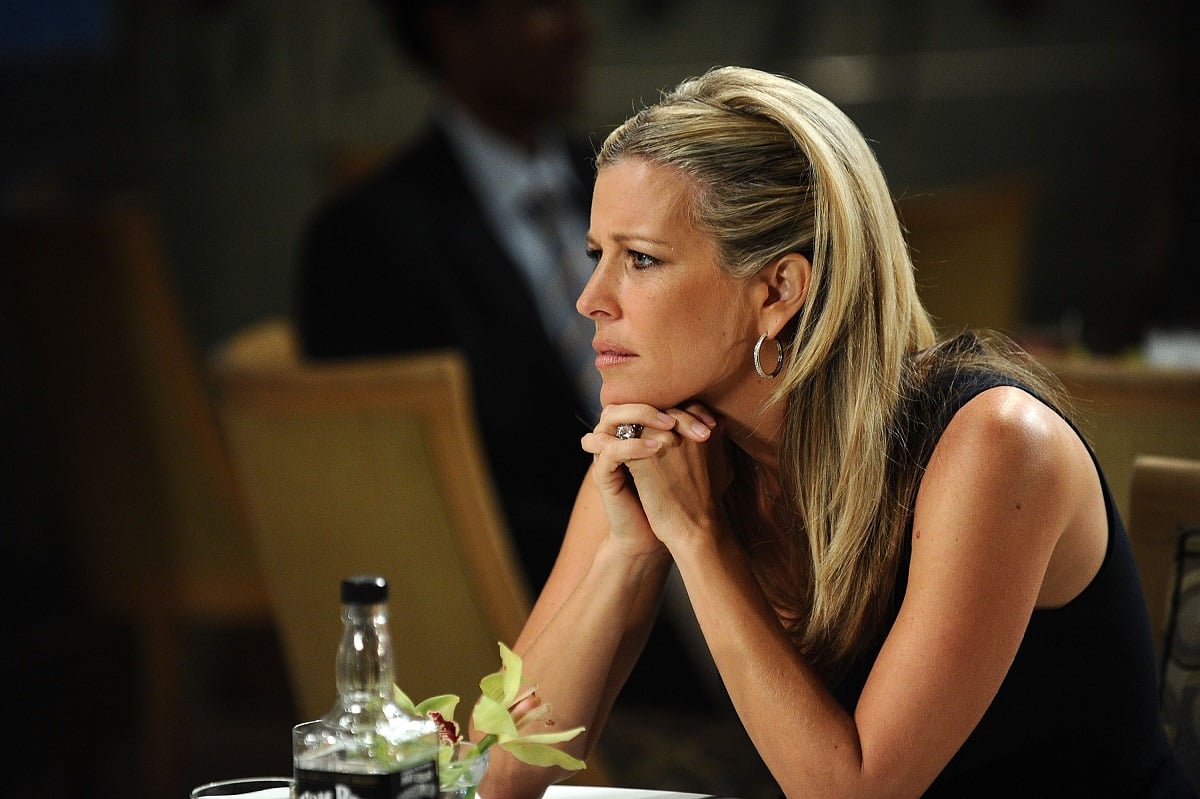 'General Hospital' star Laura Wright in a black dress and sitting at a table during a scene from the ABC soap opera.