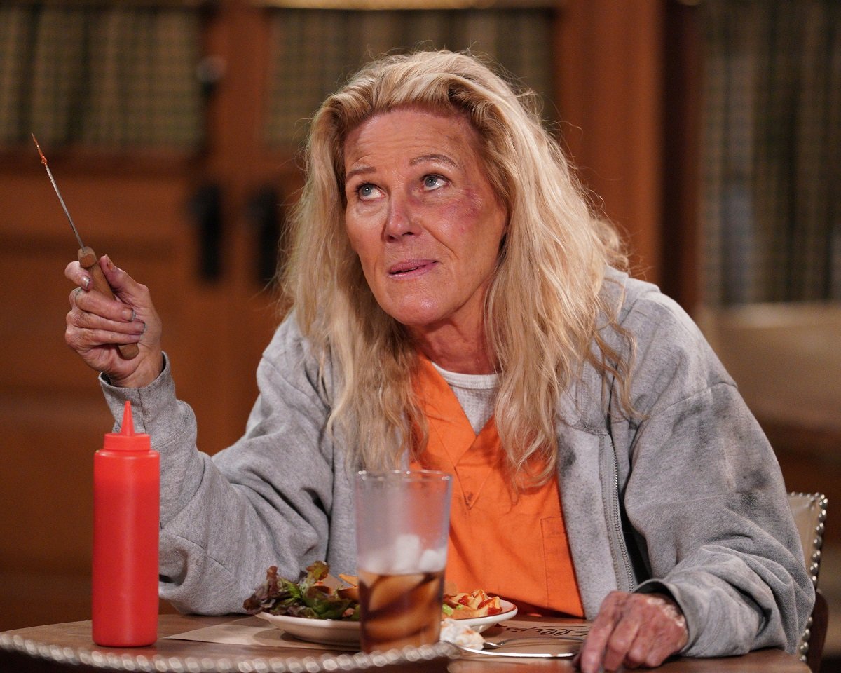 'General Hospital' star Alley Mills in an orange prison jumpsuit and holding a knife in a scene from the soap opera.