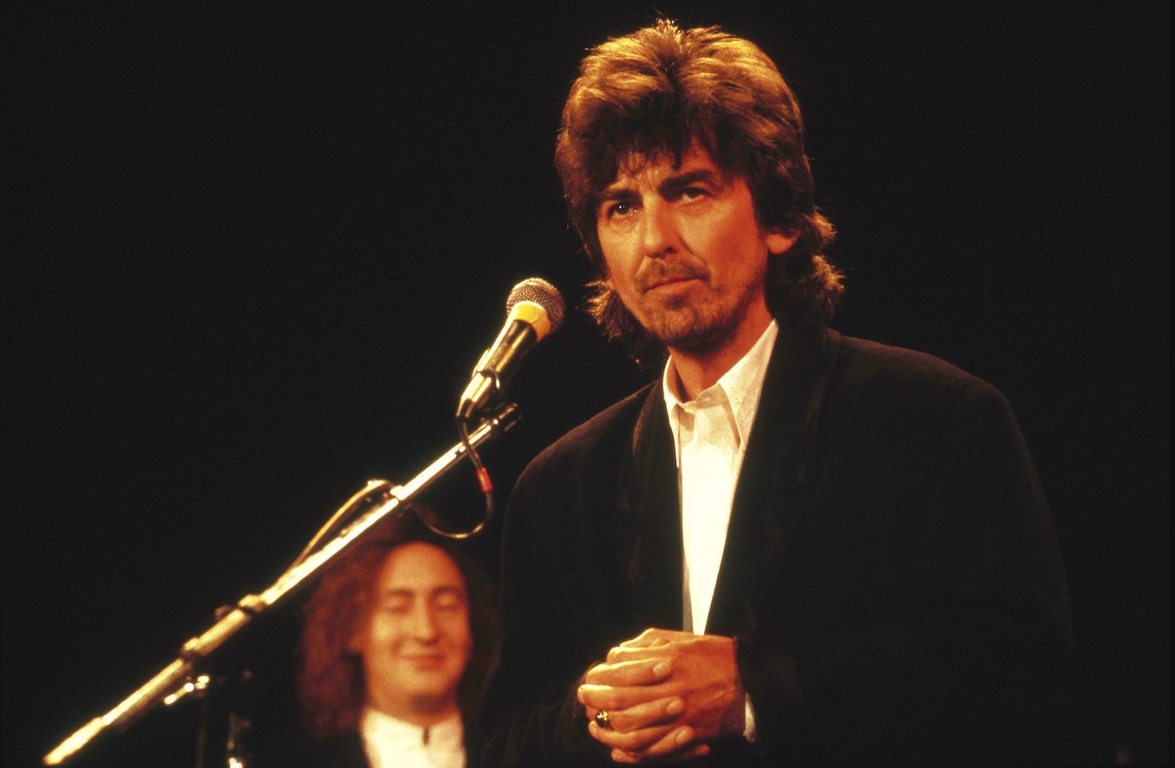 George Harrison wearing a black suit at The Beatles' Rock & Roll Hall of Fame induction in 1988.