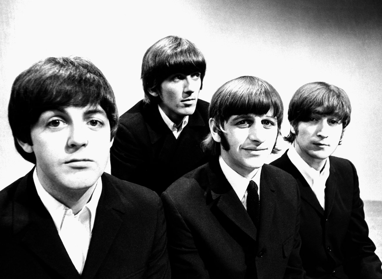 George Harrison and The Beatles posing in suits in 1966.