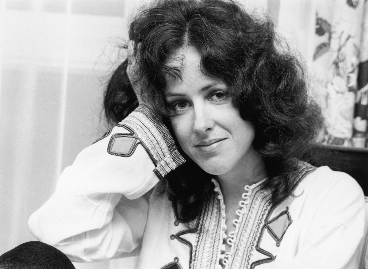 A black and white photo of Jefferson Airplane's Grace Slick, who gave her opinion on Fleetwood Mac, smiling into the camera.