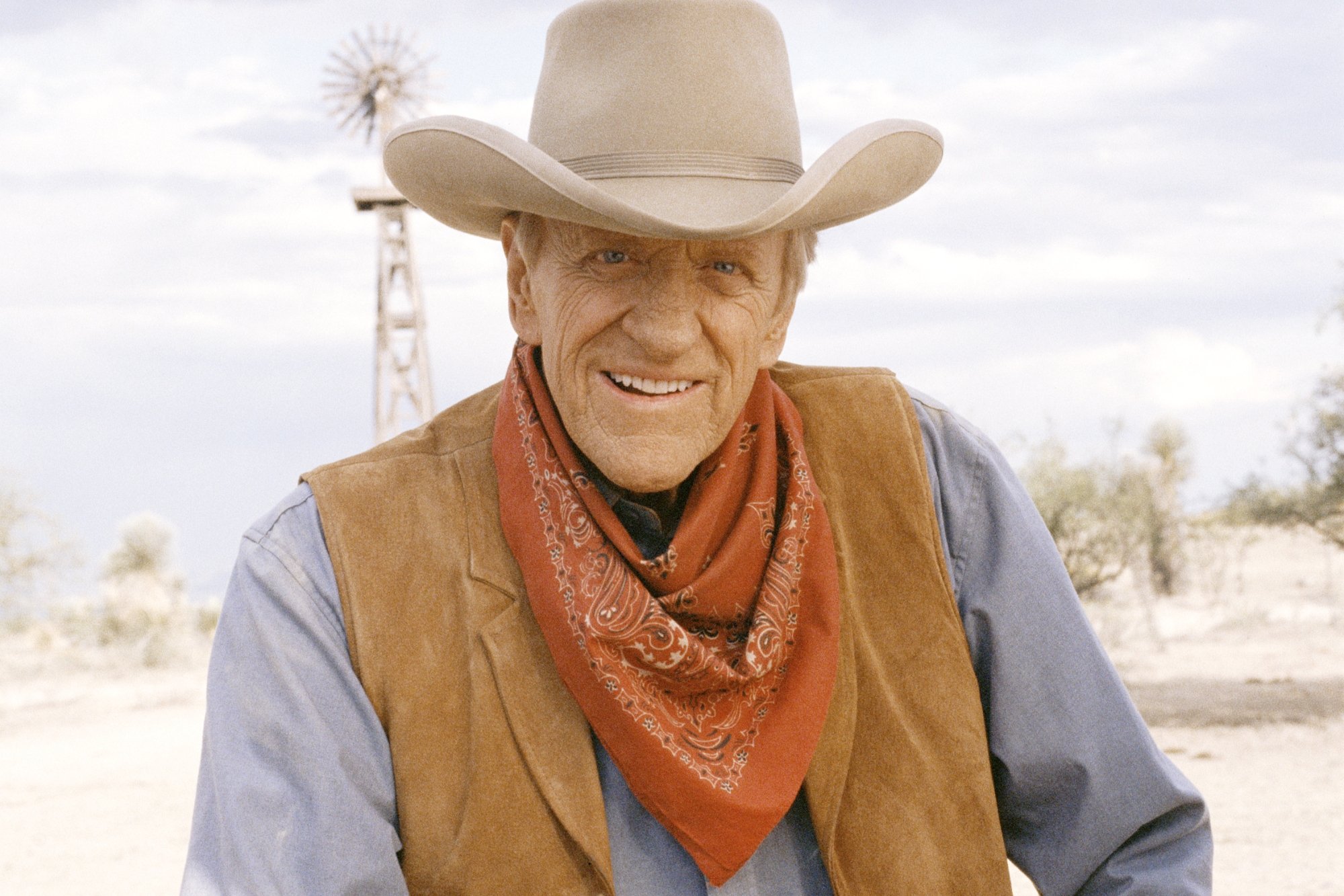 'Gunsmoke' James Arness as U.S. Marshal Matt Dillon wearing a vest, bandana around his neck, and a cowboy hat.