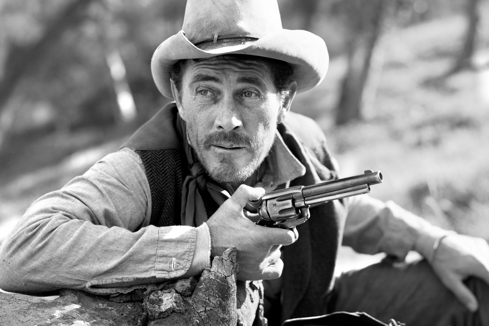 'Gunsmoke' Ken Curtis as Festus Haggen in a black-and-white photograph holding a pistol and wearing a Western outfit.