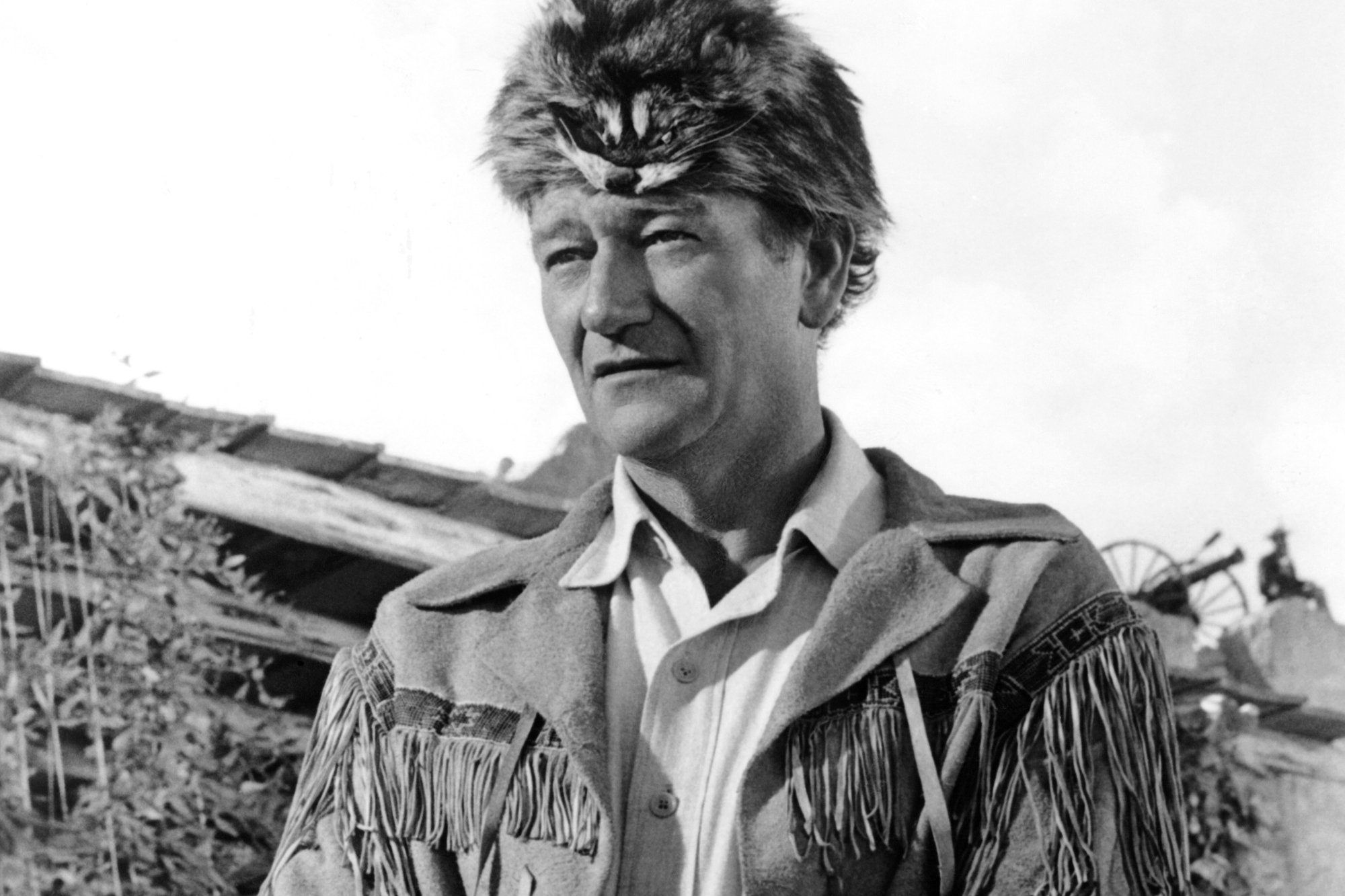 Hero movie star John Wayne in a black-and-white picture wearing a Western jacket with tassels.
