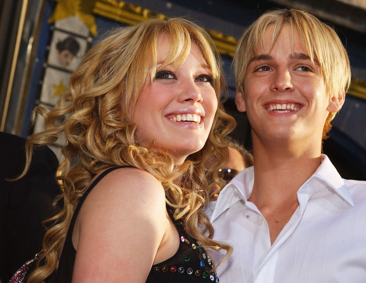 Hilary Duff and Aaron Carter smile and pose together at an event as teenagers.