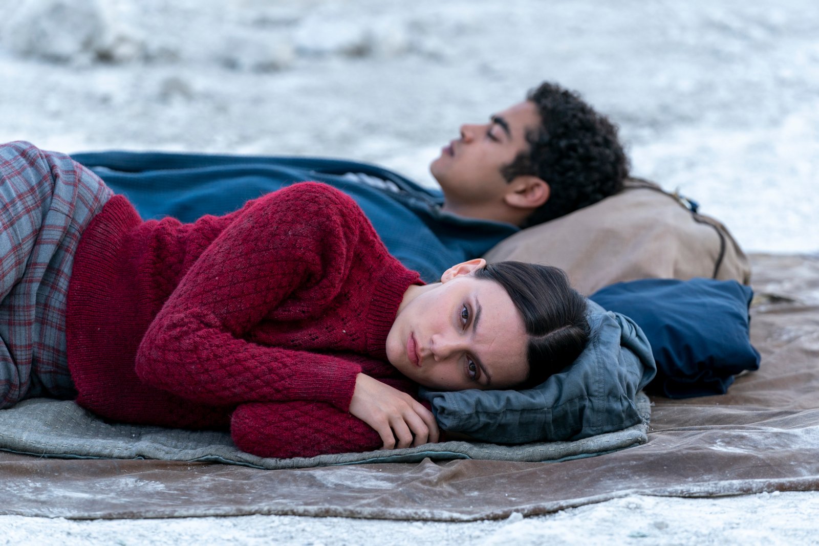 Dafne Keen and Amir Wilson as Lyra and Will in 'His Dark Materials' Season 3, which will serve as the show's ending. They're laying next to one another on an icy floor.