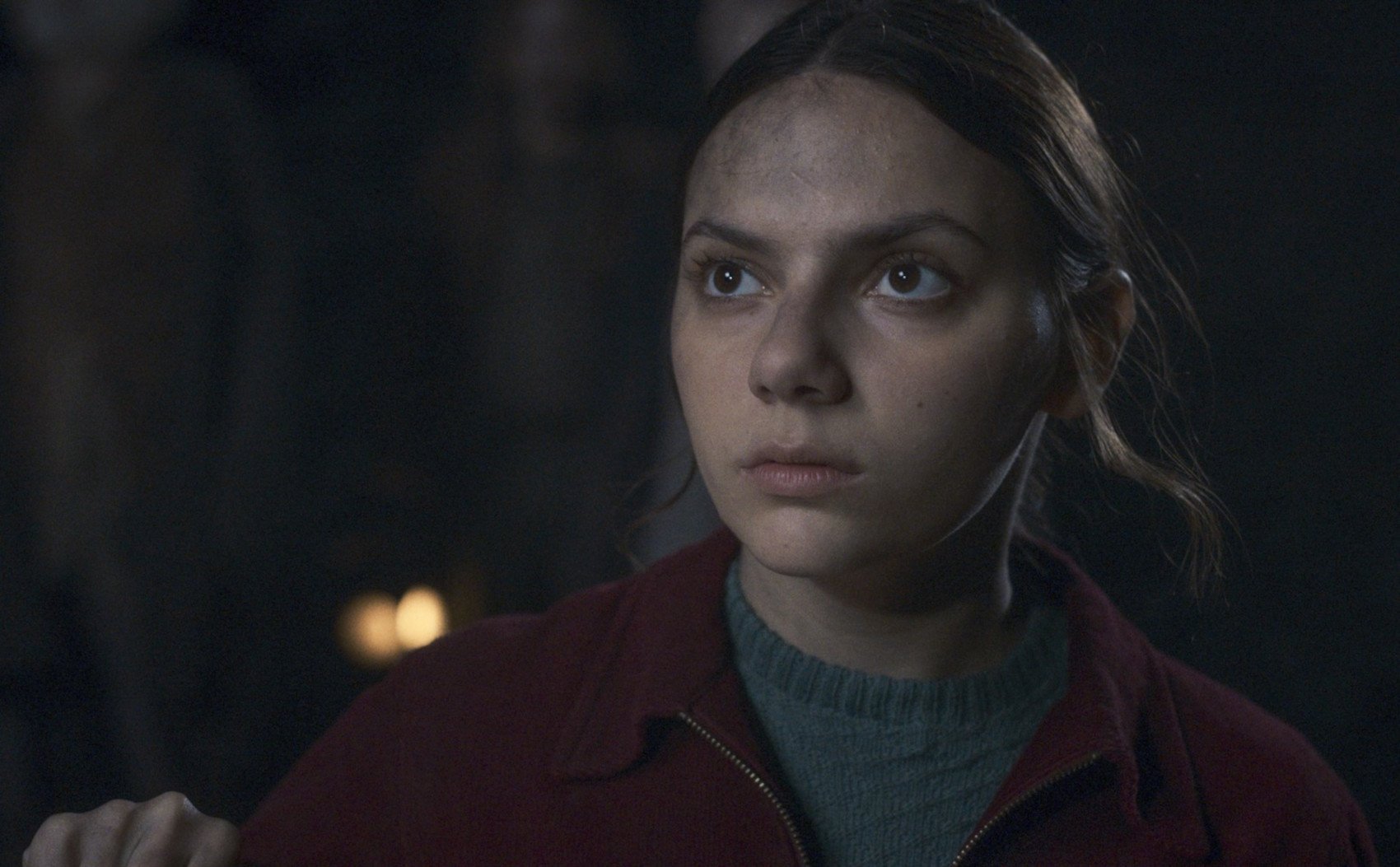 Dafne Keen as Lyra Silvertongue in 'His Dark Materials' Season 3. Her hair is pulled back, and she looks serious.