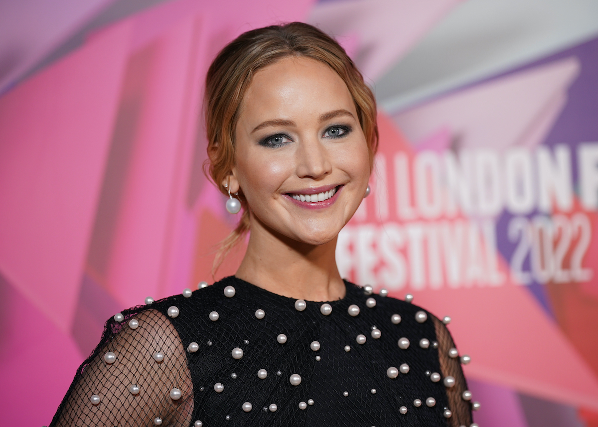 Jennifer Lawrence smiles in a black dress with white baubles at the 'Causeway' premiere