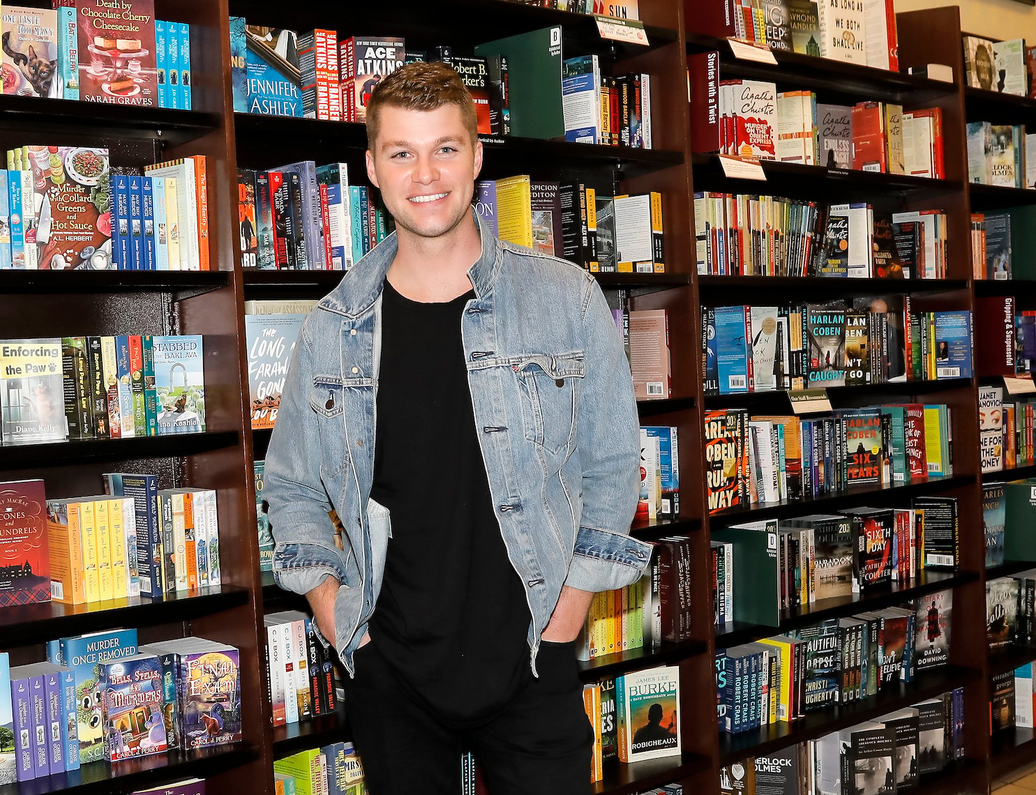 'Little People, Big World' star Jeremy Roloff smiling and standing against a bookshelf