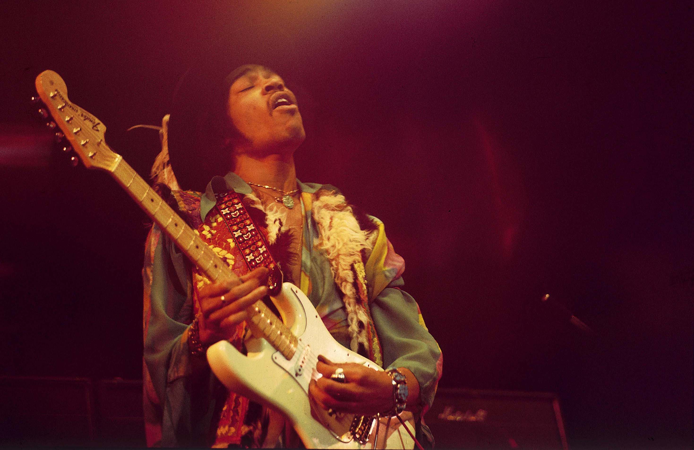 Jimi Hendrix, who once shared a bed with a bandmate, playing guitar