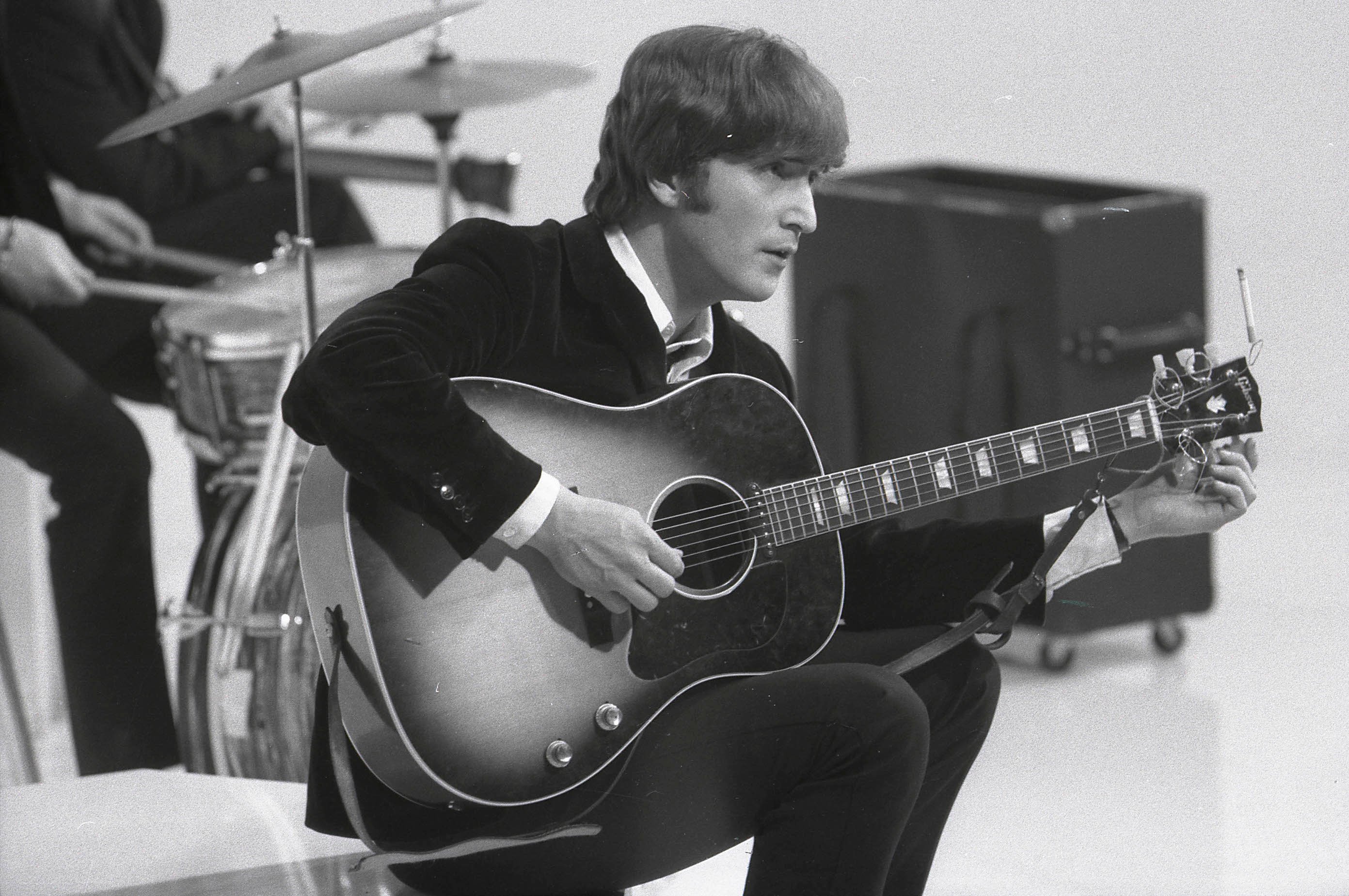 John Lennon tuning his guitar during the filming of 'A Hard Day's Night'