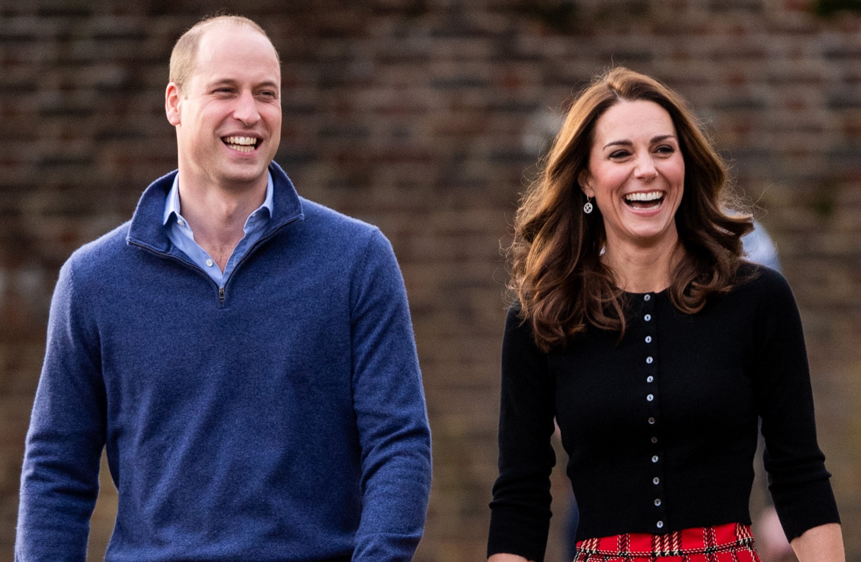 Kate Middleton and Prince William laugh together. The Prince and Princess of Wales show relaxed and happy body language.