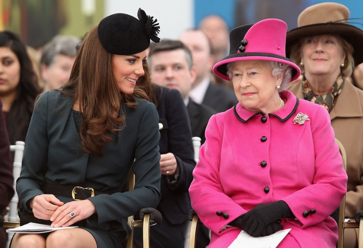 Kate Middleton, whose 2022 Christmas carol concert invitation featured an illustration with corgis as a nod to Queen Elizabeth, sits next to Queen Elizabeth II in 2012