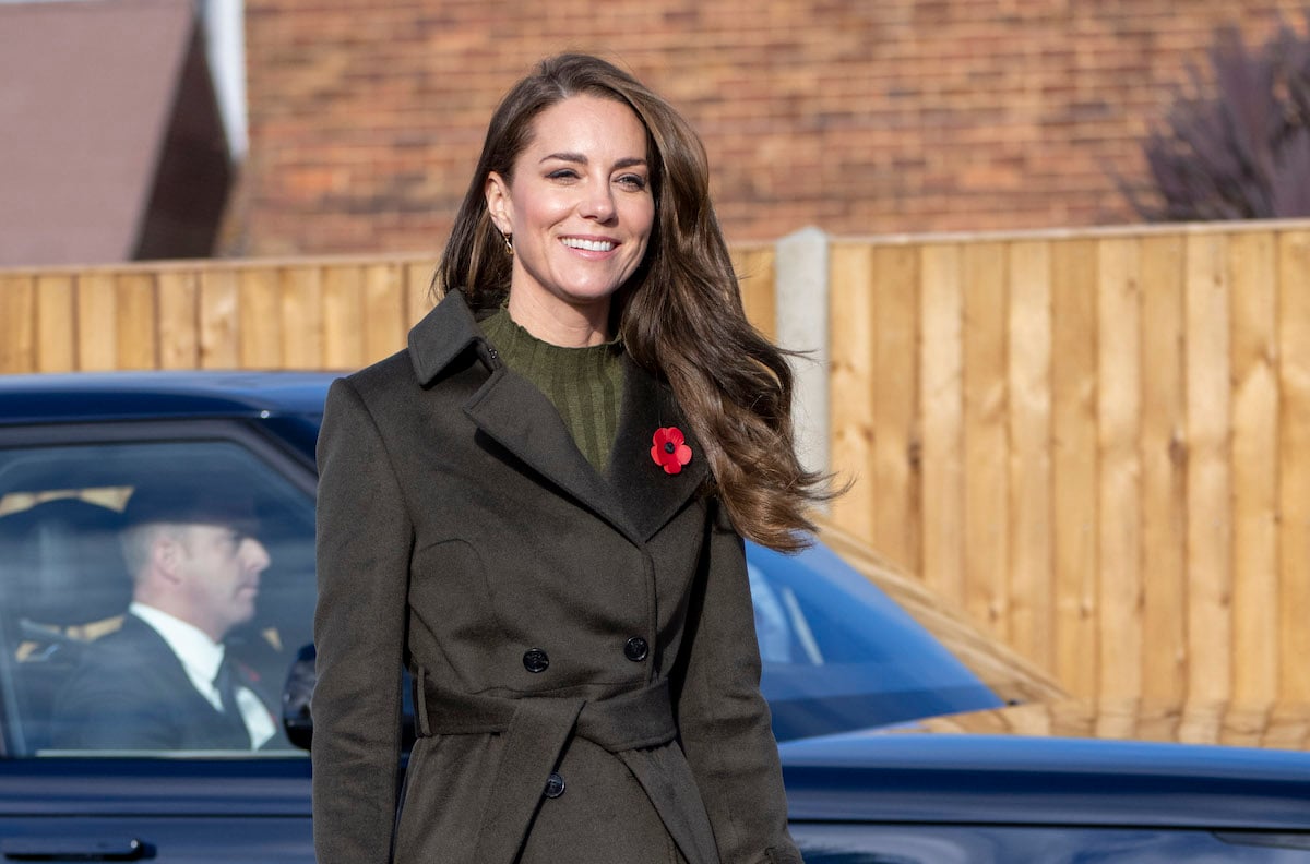 Kate Middleton smiles wearing a green coat and poppy pin to visit Colham Manor Children's Centre on Nov. 9, 2022, where a video showed her talking to Akeem, 3. 