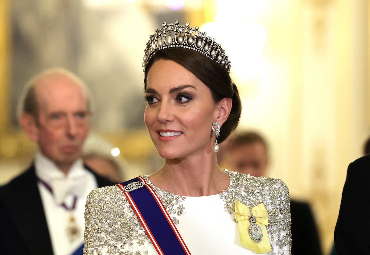 Kate Middleton, whose white state dinner gown by Jenny Packham 'made a very clear statement' according to commentator Daniela Elser, smiles and looks on