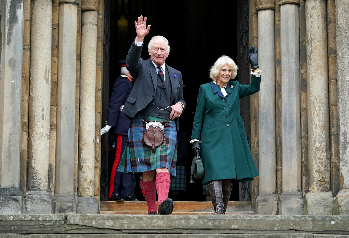 King Charles III and Camilla Parker wave as they walk to meet members of the public in Dunfermline in Scotland