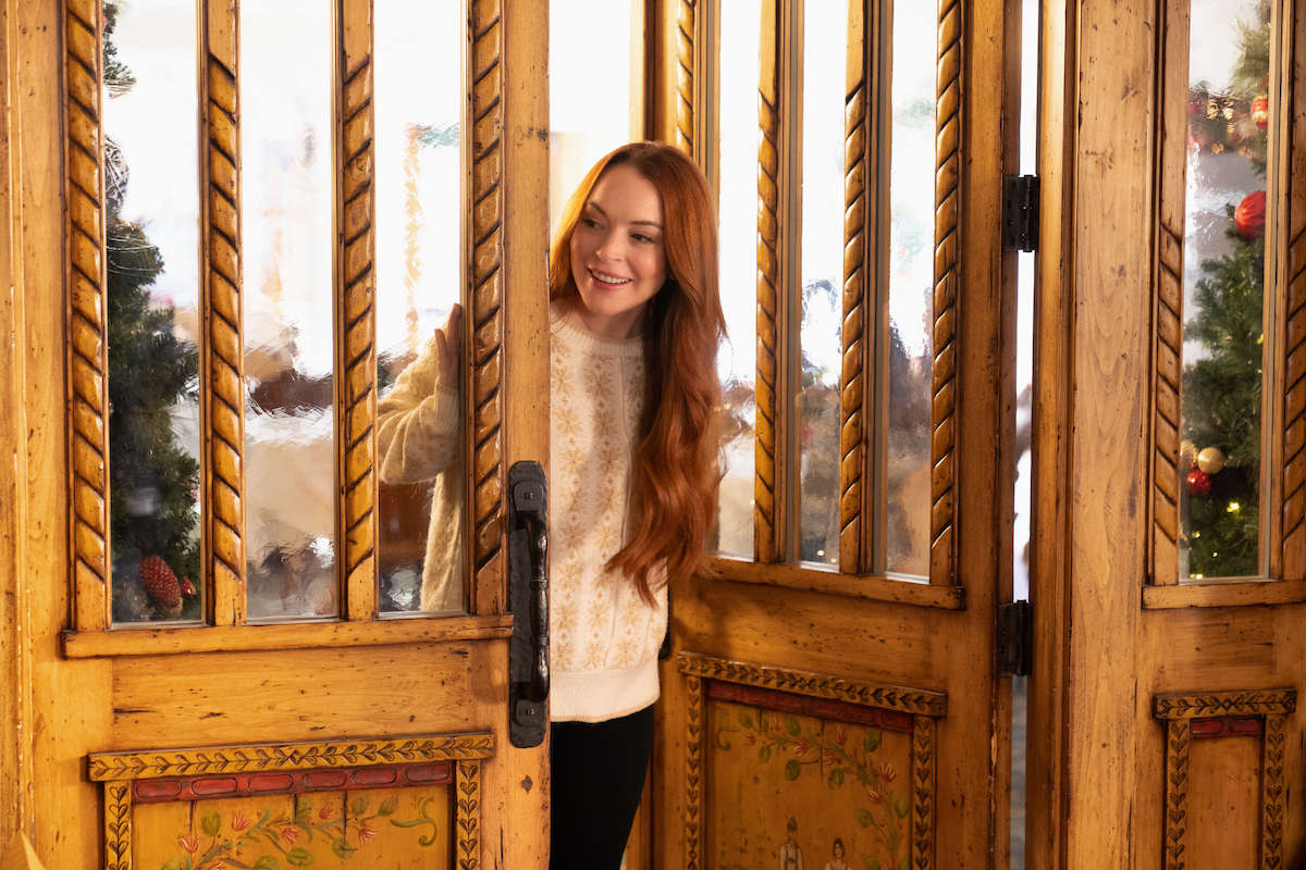 Lindsay Lohan looking through a door in the Netflix movie 'Falling for Christmas'