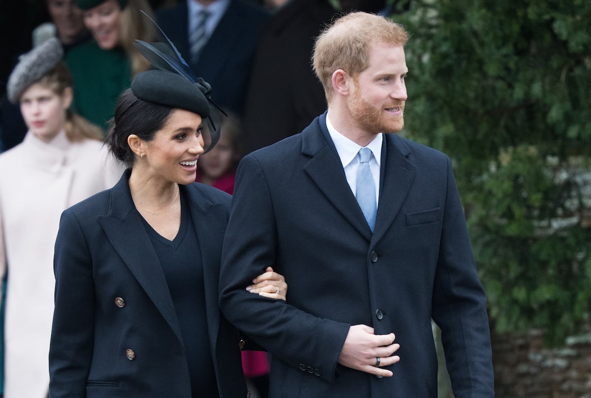 Meghan Markle and Prince Harry, who would 'dampen' the royal family's plans for Christmas at Sandringham, according to expert Angela Levin, smile and look on during Christmas at Sandringham in 2018