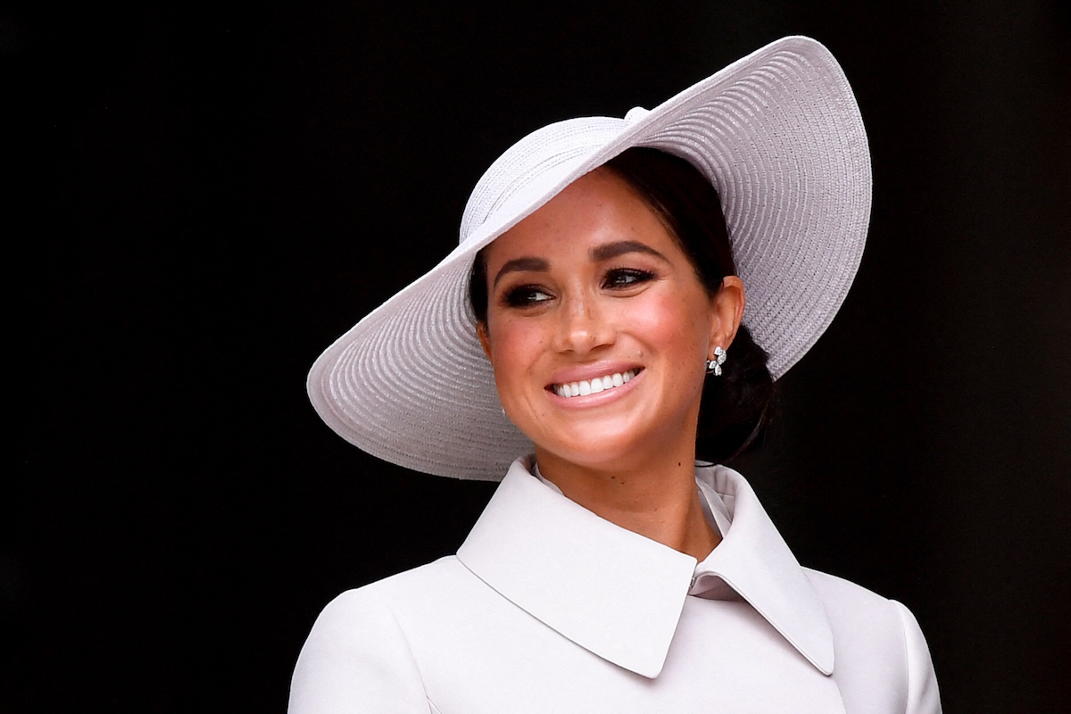 Meghan Markle, who wants Archie and Lilibet to 'be able to carve out their own path,' smiles wearing a gray hat and coat