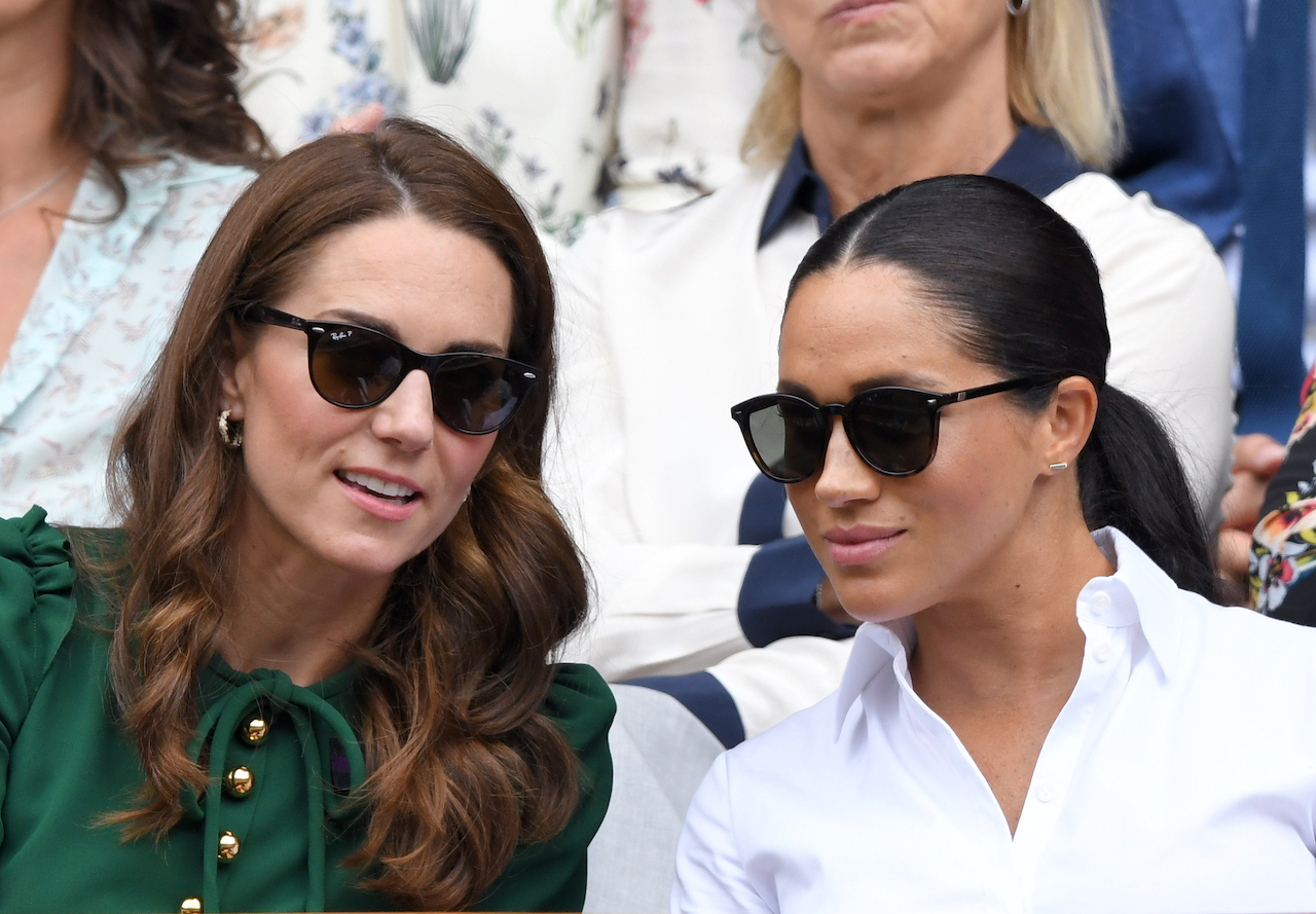 Kate Middleton, Princess of Wales, and Meghan Markle, Duchess of Sussex in the Royal Box on Centre Court during day twelve of the Wimbledon Tennis Championships at All England Lawn Tennis and Croquet Club on July 13, 2019, in London, England. 