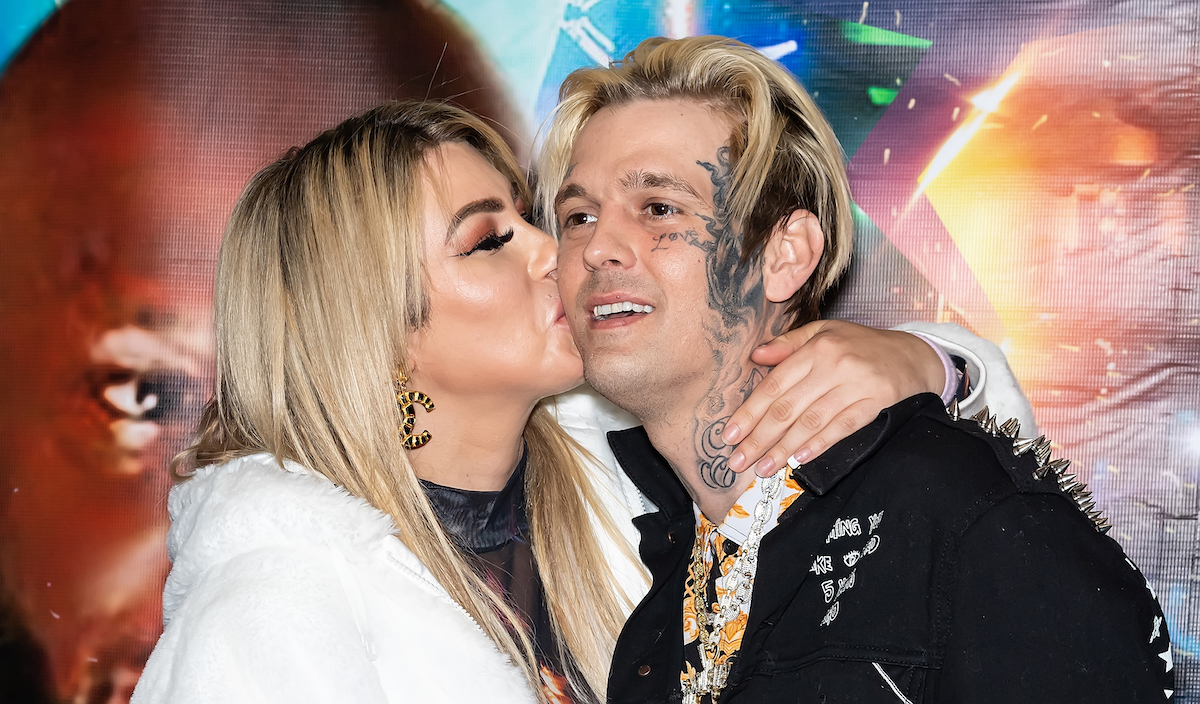 Aaron Carter (R) and his ex-fiancée Melanie Martin kissing his cheek at an event