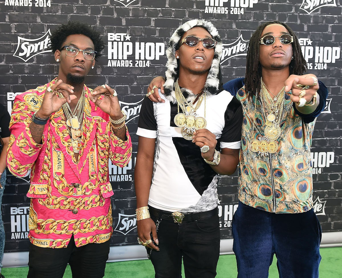 Migos members Takeoff, Offset, and Quavo pose together at an event.