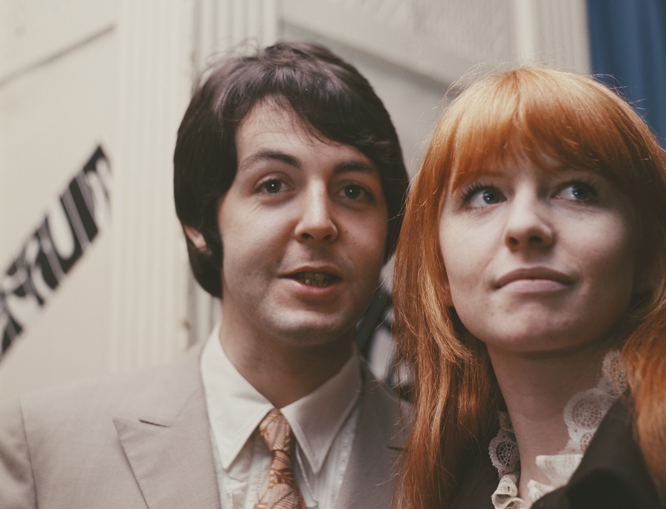 Paul McCartney wears a suit and stands next to Jane Asher, who wears a lace collar.