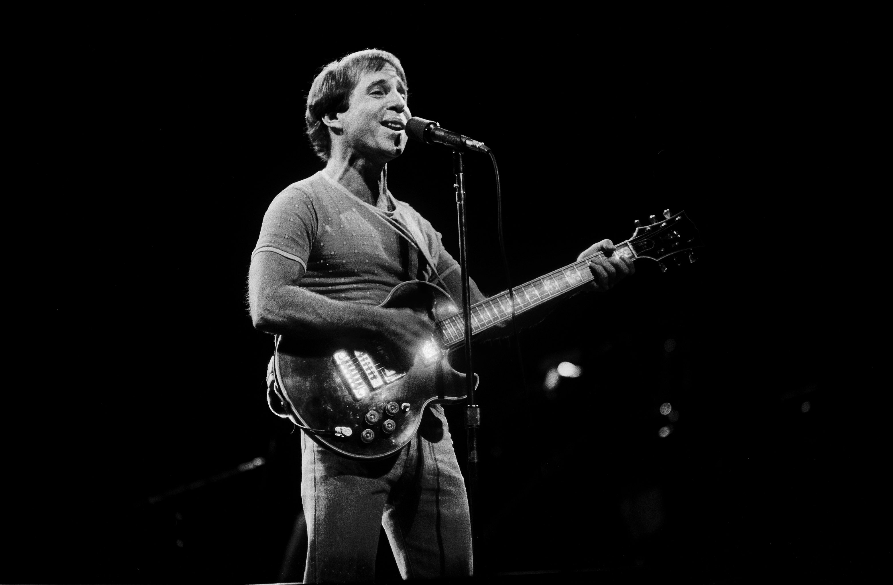 Paul Simon holding a guitar