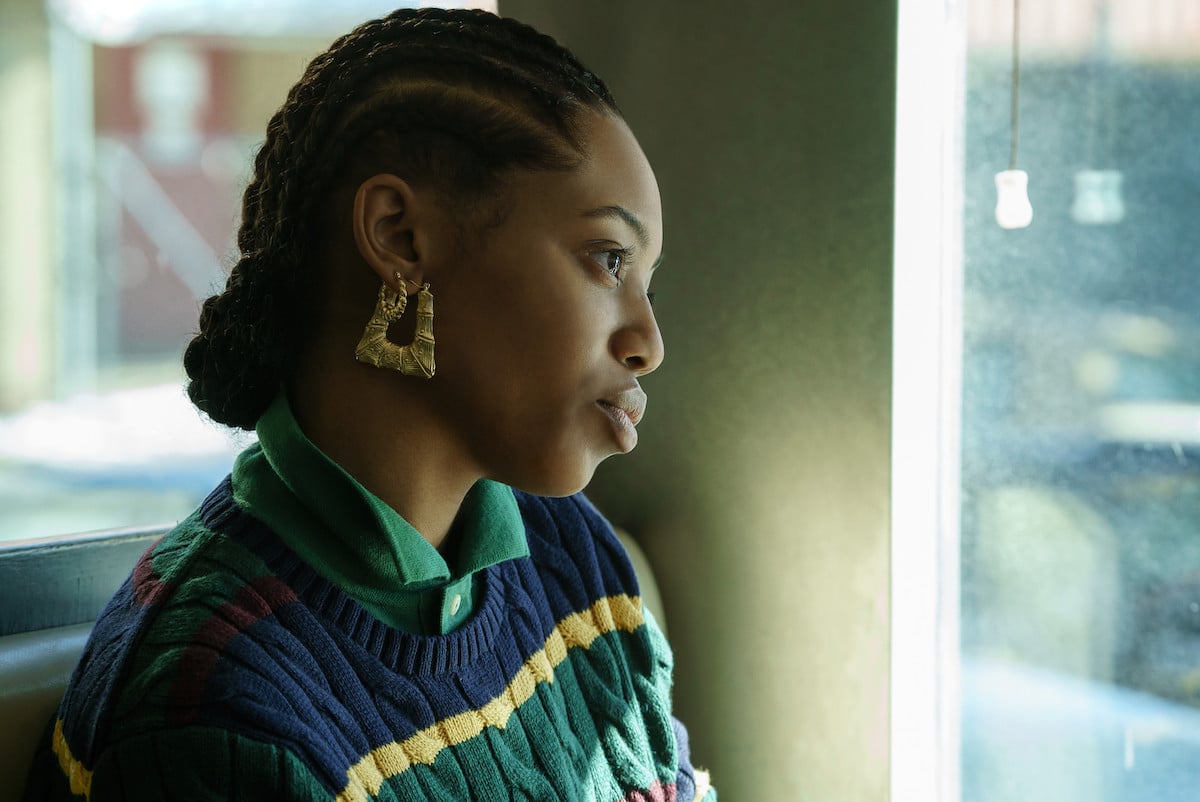 Hailey Kilgore as Jukebox in chunky gold earrings and a collard shirt in 'Power Book III: Raising Kanan'