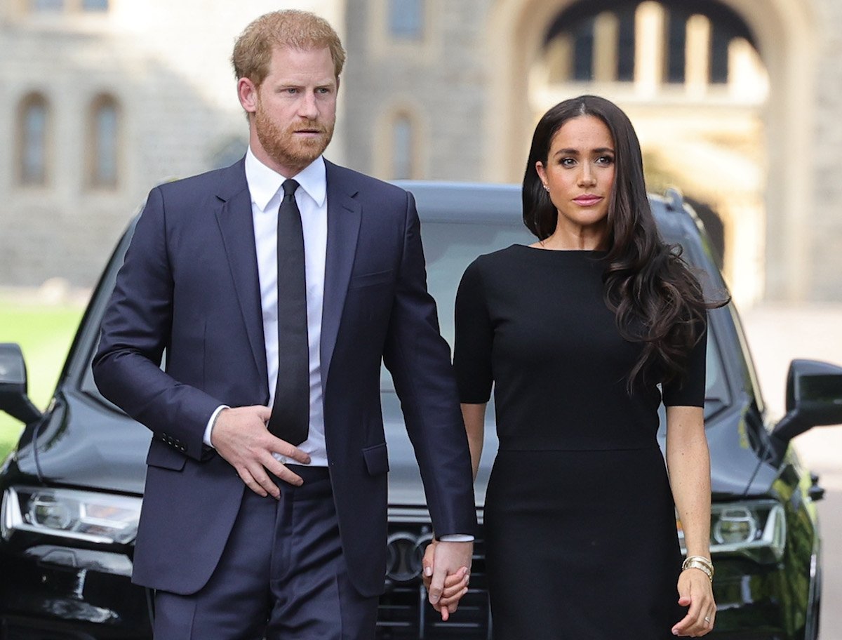 Prince Harry and Meghan Markle, who made 'rifts' look nonexistent in Dusseldorf, Germany, on Sept. 6, 2022, according to body language expert Judi James, walk together outside Windsor Castle after Queen Elizabeth II's death