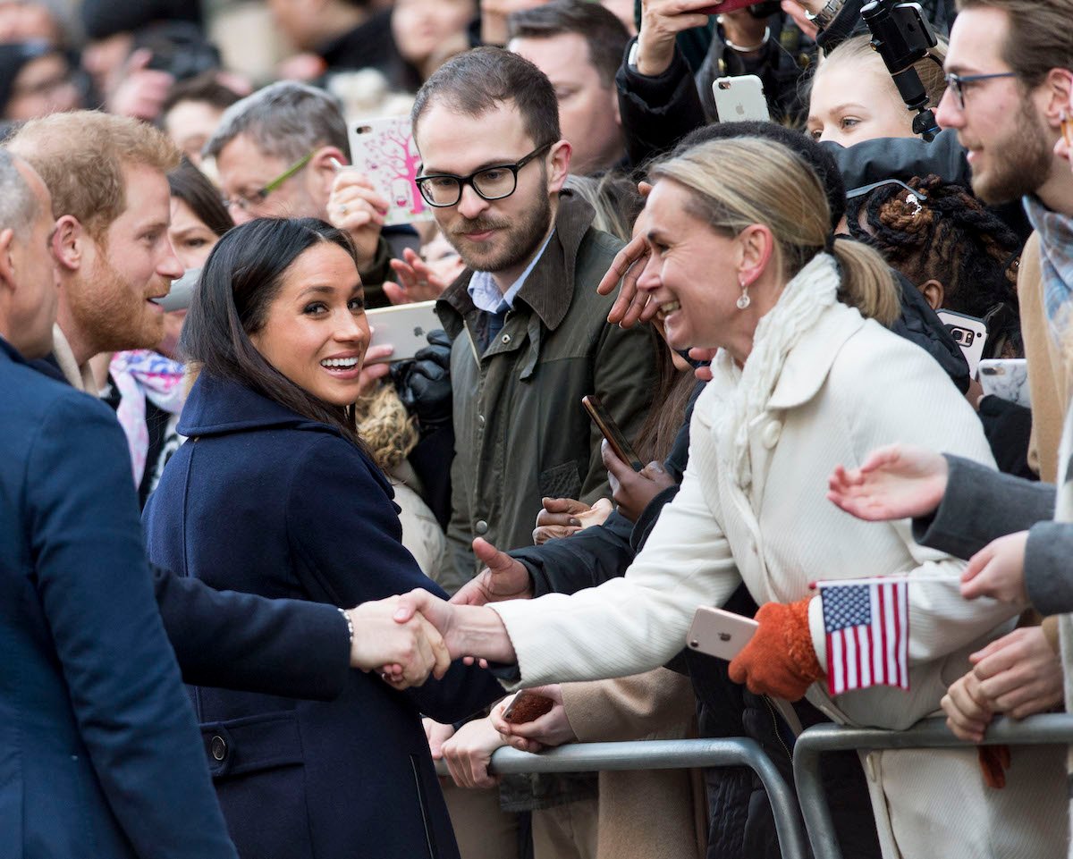 Prince Harry and Meghan Markle, who didn't exhibit body language 'red flags' like Prince Harry's ex, Chelsy Davy, according to an expert, greet crowds in 2017