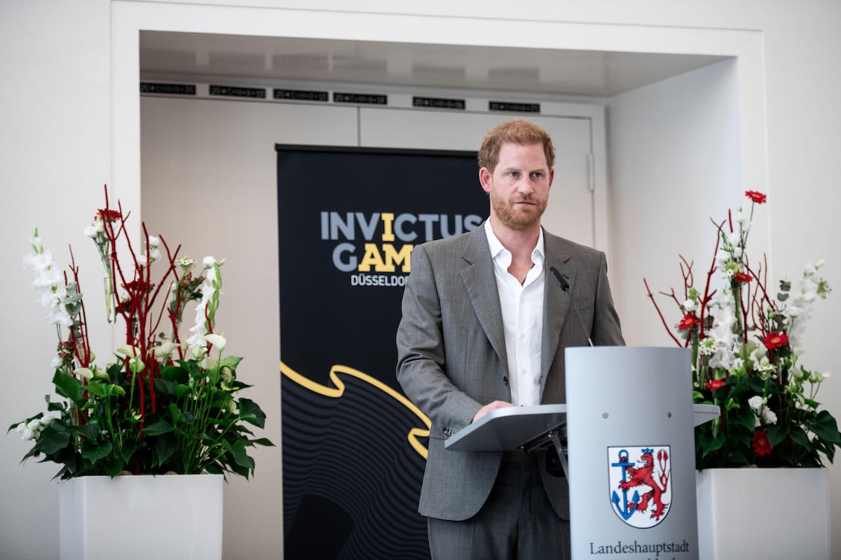 Prince Harry, whose 'Spare' memoir has been dubbed 'critic-proof', stands at a podium