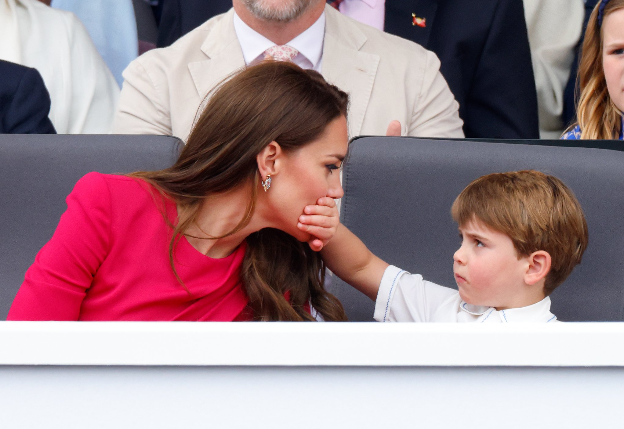 Prince Louis covers his mom Kate Middleton's mouth with his hand during the Platinum Jubilee Pageant