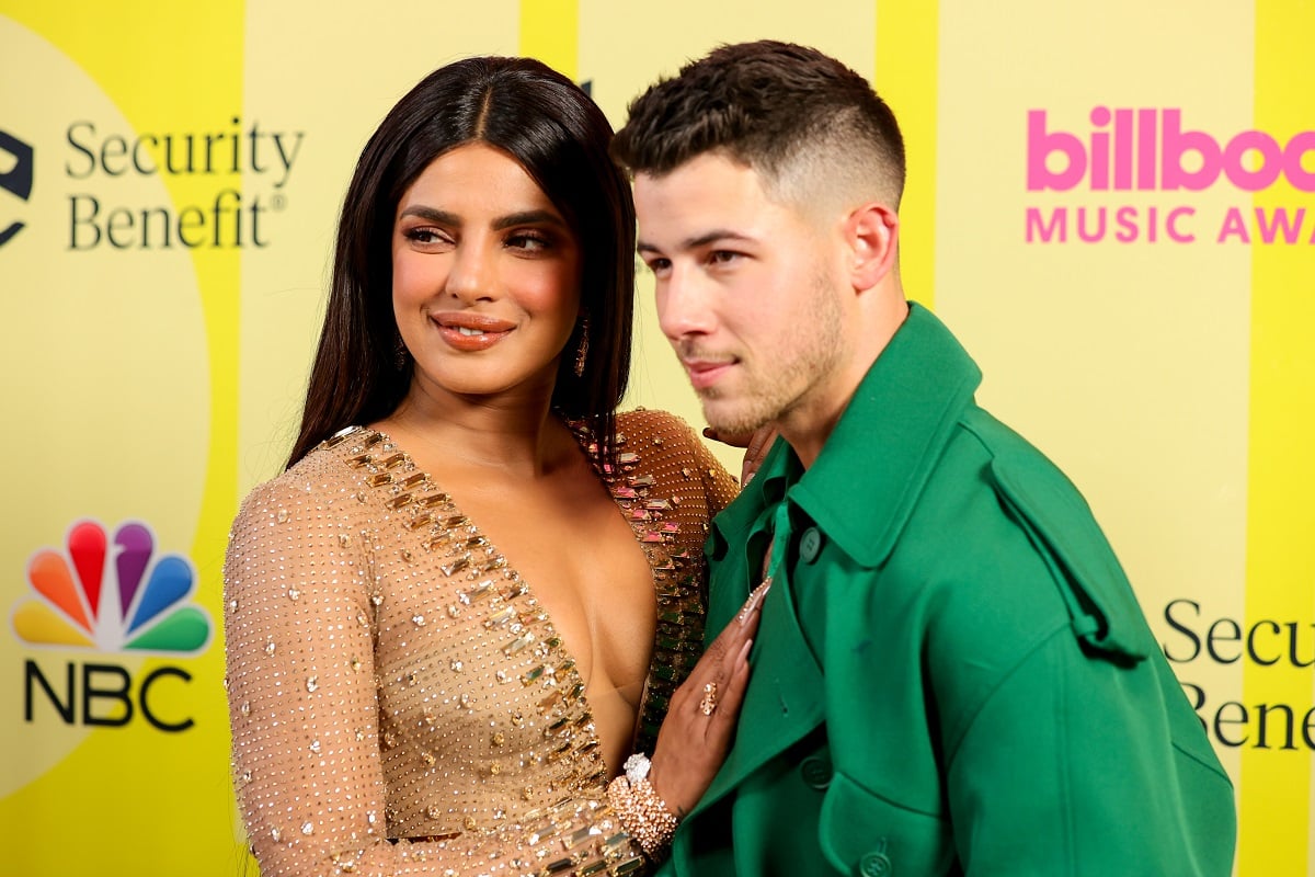 Priyanka Chopra Jonas and Nick Jonas pose backstage for the 2021 Billboard Music Awards
