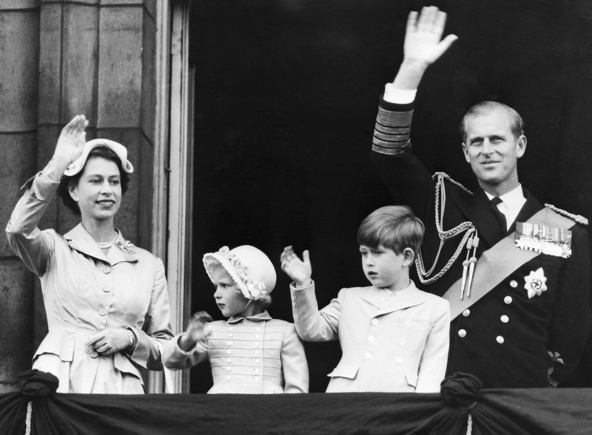 Queen Elizabeth II, who shook King Charles III's hand in a childhood photo from 1954 in what an author called a 'heartbreaking' photo, stands with Princess Anne, King Charles III, and Prince Philip on the Buckingham Palace balcony and waves after a commonwealth tour