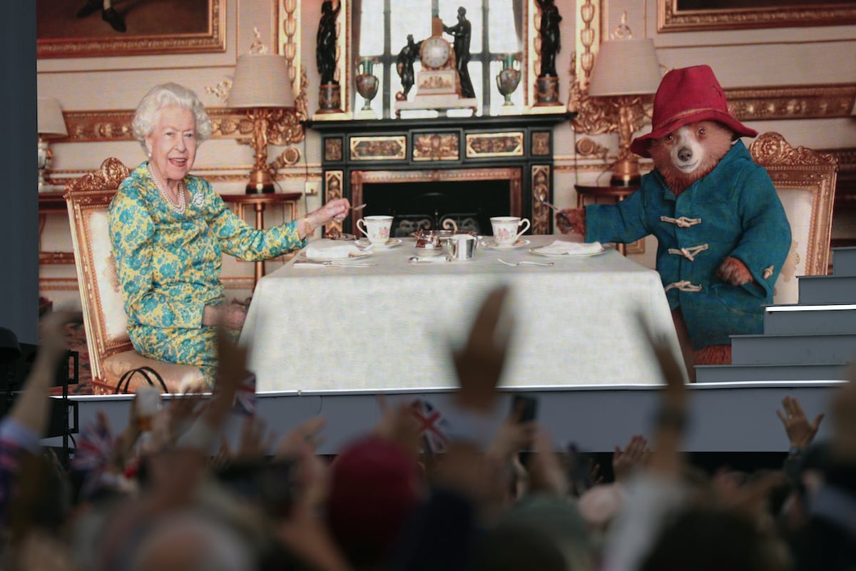 Queen Elizabeth II has tea with Paddington Bear, whose teddy bears left by mourners were featured in photos around Buckingham Palace and Clarence House before Camilla Parker Bowles donates them to charity
