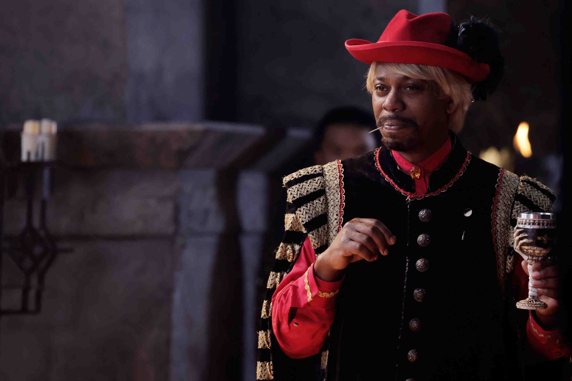 'Saturday Night Live' host Dave Chappelle wearing a red hat, black vest, and red sleeves.