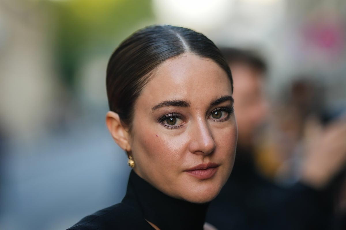 Shailene Woodley looks into the camera while wearing a black dress